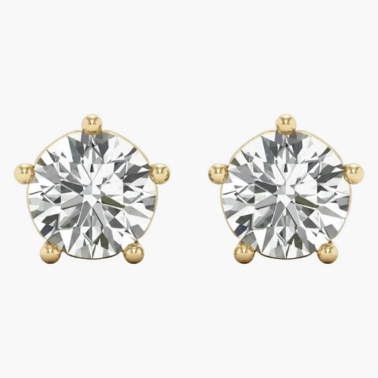 A pair of round-cut diamond stud earrings in yellow gold four-prong settings, shown against a plain light gray background.
