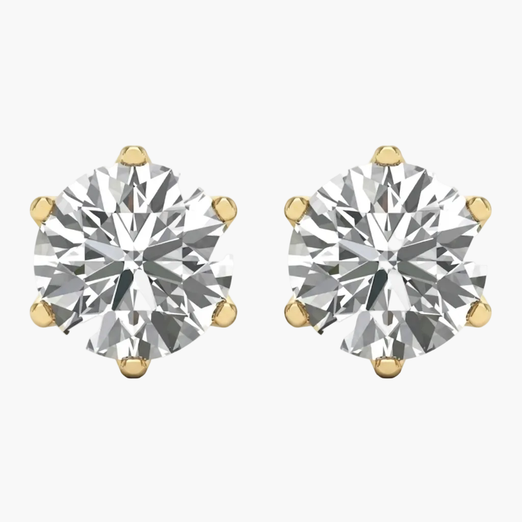 A pair of round-cut diamond stud earrings in yellow gold four-prong settings, shown on a plain white background.
