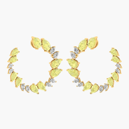 Gold earrings with yellow gemstones on a white background