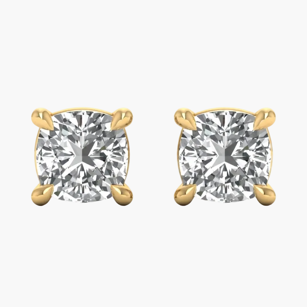 A pair of yellow gold stud earrings with cushion-cut clear gemstones in four-prong settings, shown on a plain white background.