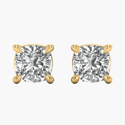 A pair of yellow gold stud earrings with cushion-cut clear gemstones in four-prong settings, shown on a plain white background.