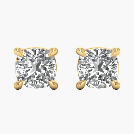 A pair of yellow gold stud earrings with cushion-cut clear gemstones in four-prong settings, shown on a plain white background.