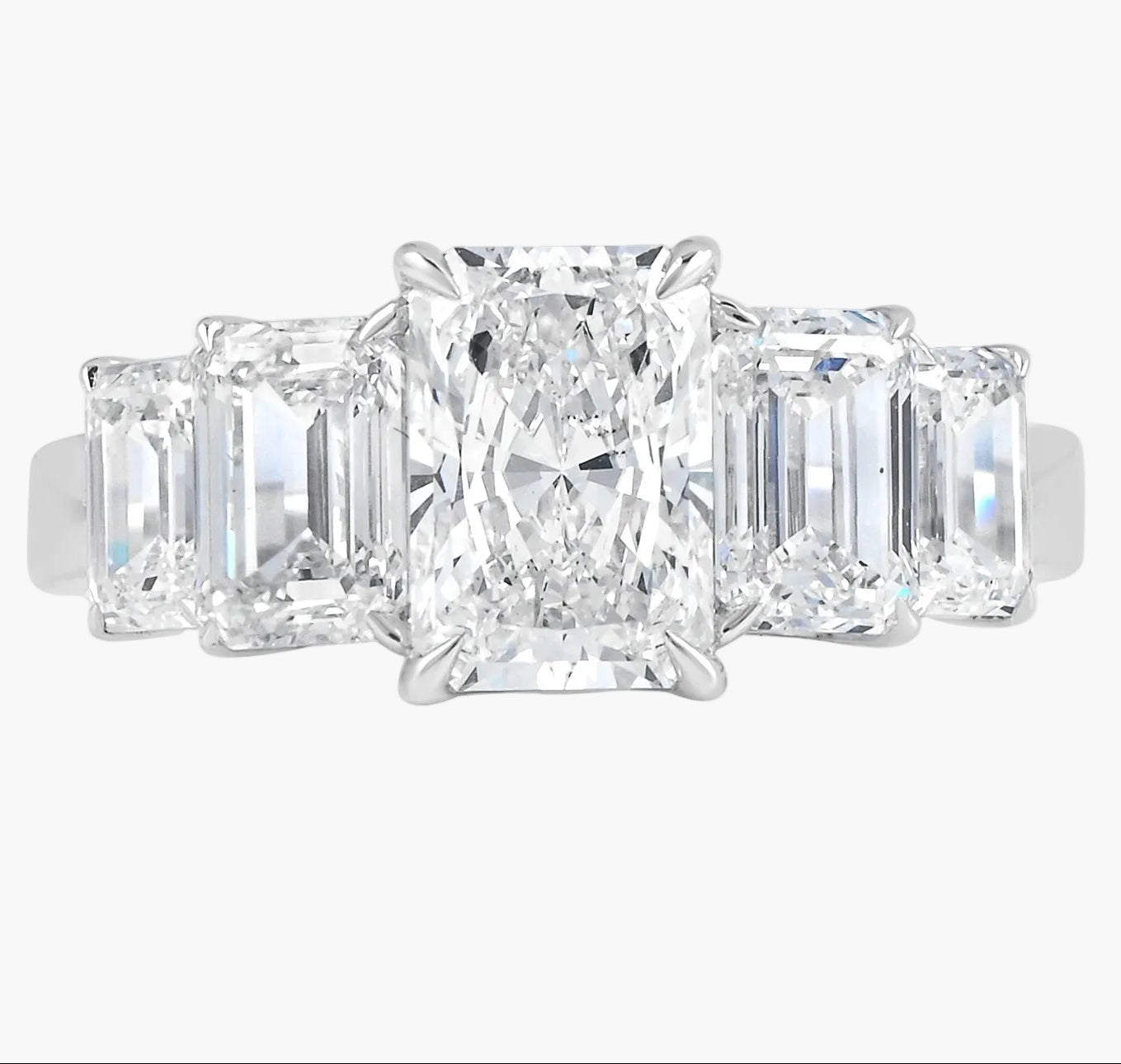 Diamond ring with three rectangular-cut diamonds on a white background