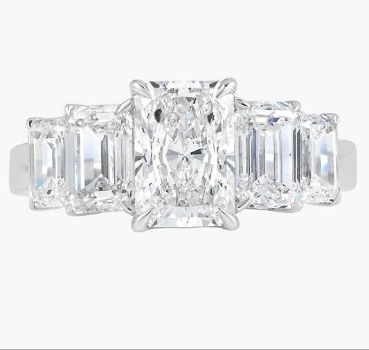 Diamond ring with three rectangular-cut diamonds on a white background