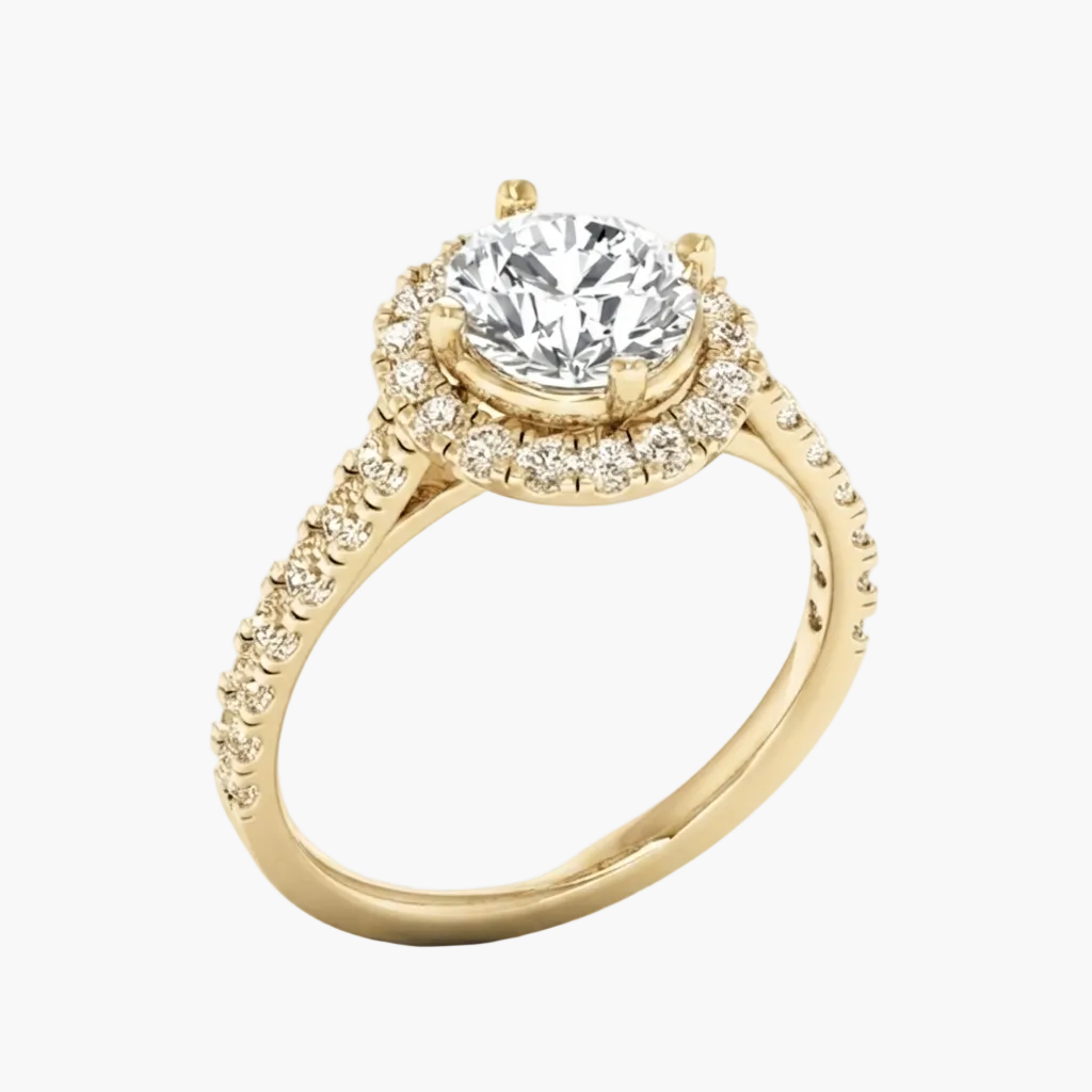 A yellow gold engagement ring featuring a round-cut center stone and a halo of smaller diamonds, with a split shank accented by pavé diamonds, shown on a white background.