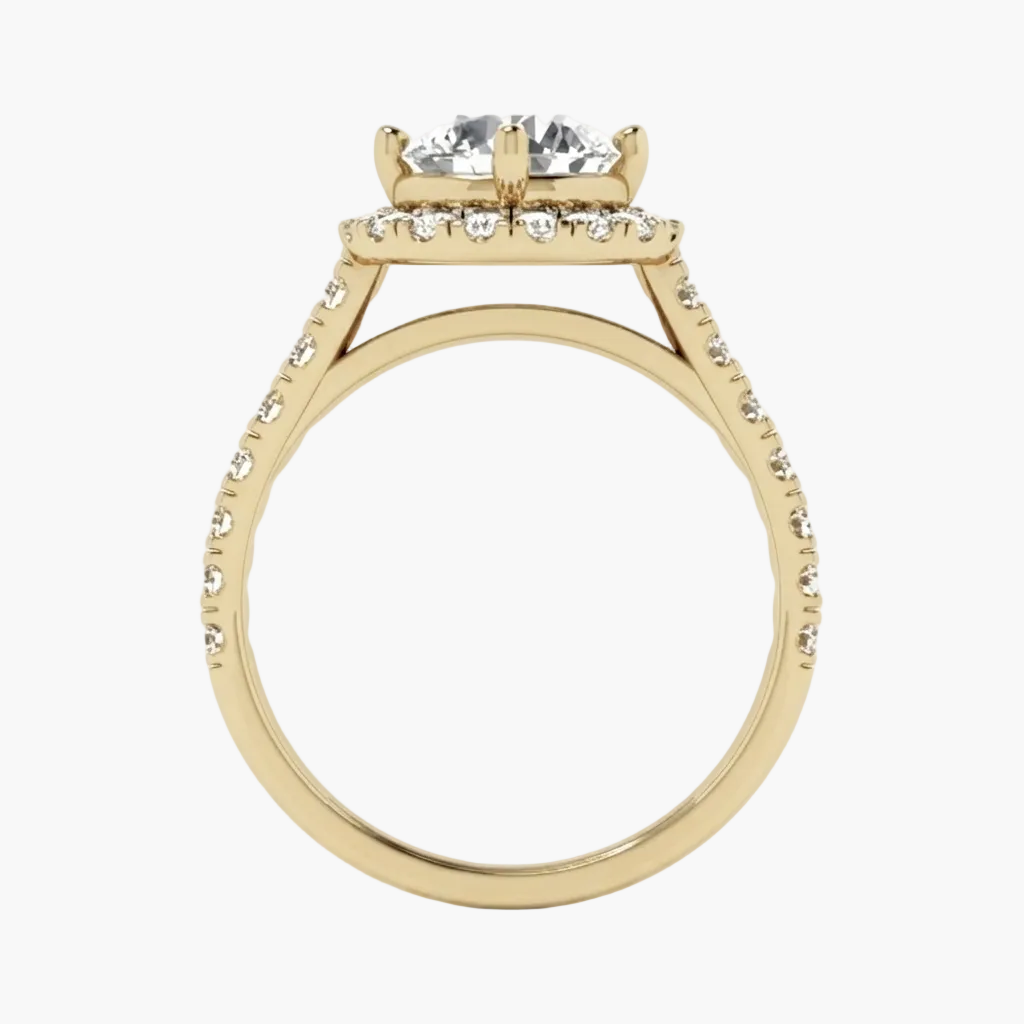 A yellow gold ring with a four-stone diamond solitaire setting, a halo of small diamonds, and a shank paved with diamonds, shown on a plain white background.