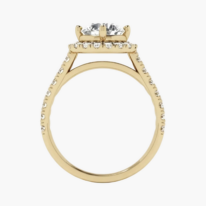 A yellow gold ring with a four-stone diamond solitaire setting, a halo of small diamonds, and a shank paved with diamonds, shown on a plain white background.