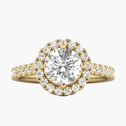 A yellow gold halo engagement ring featuring a round brilliant-cut center stone surrounded by a double halo of small pavé-set diamonds, with a split shank band also accented with diamonds, shown on a light gray background.
