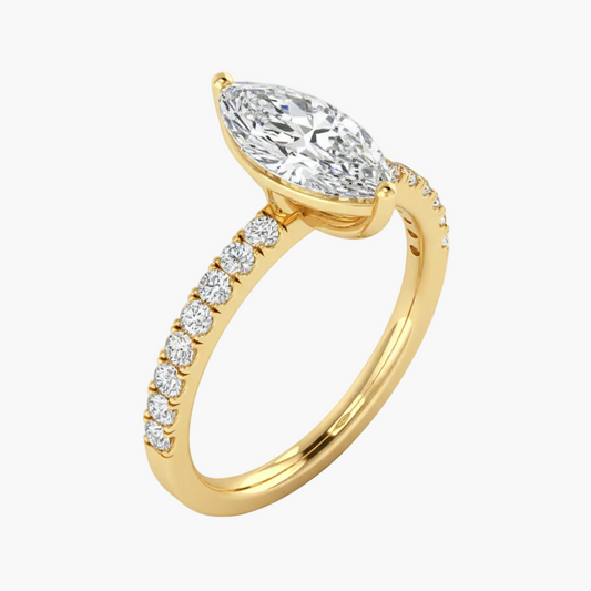 Gold ring with a large diamond and smaller diamonds on the band against a white background