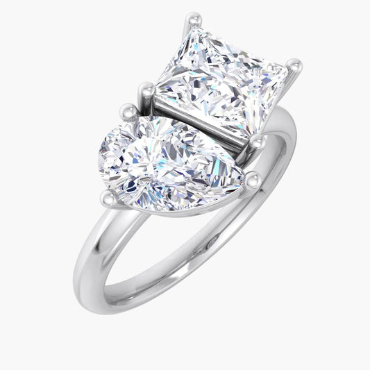 Diamond ring with heart-shaped and princess-cut diamonds on a white background