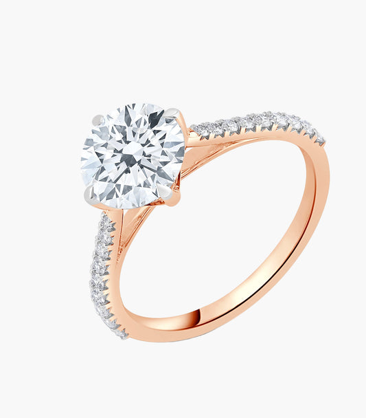 Rose gold ring with a large diamond and smaller diamonds on the band against a white background