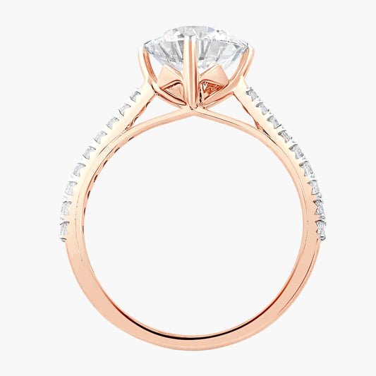 Rose gold ring with a large diamond and smaller diamonds on the band against a white background