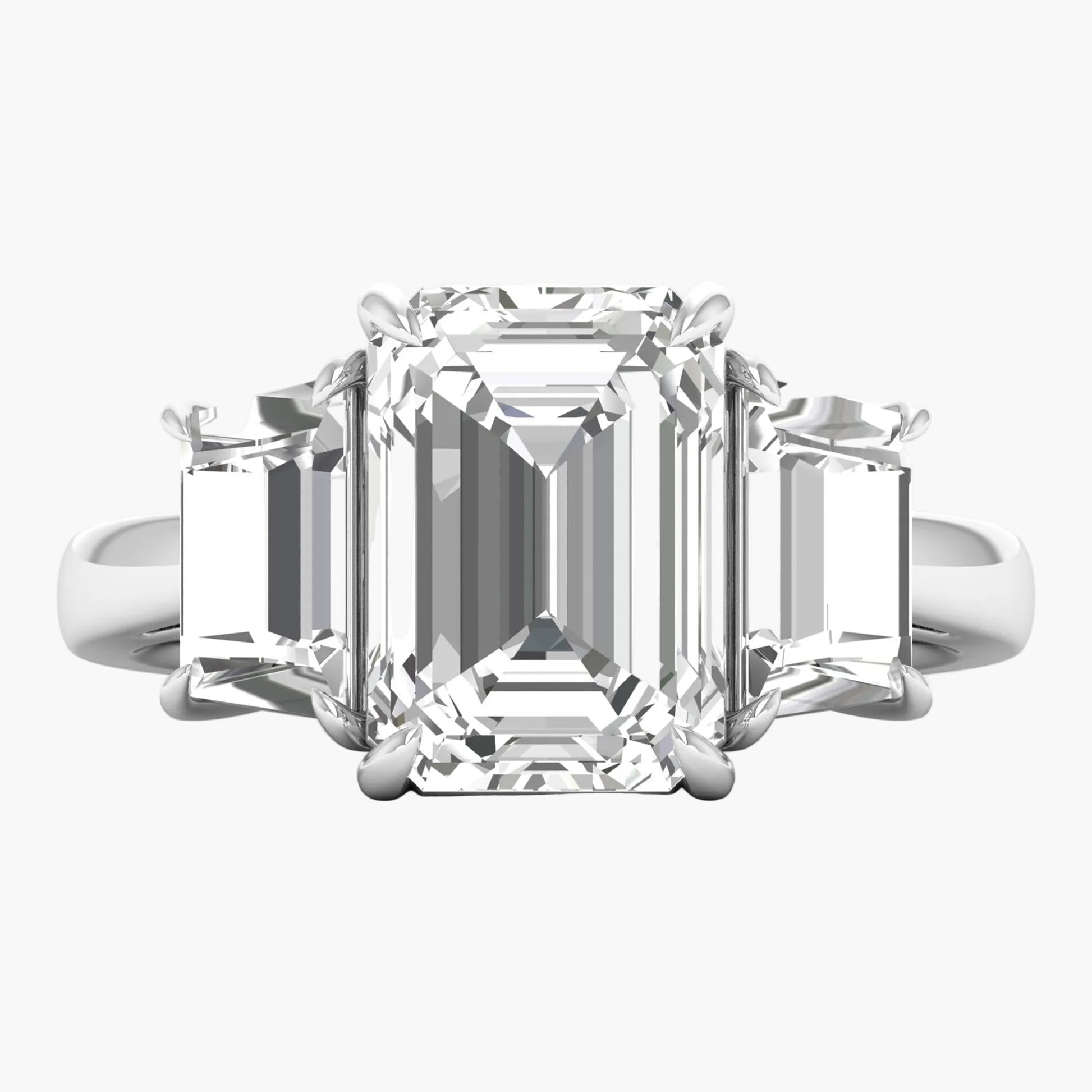 Diamond ring with emerald-cut center stone on a white background