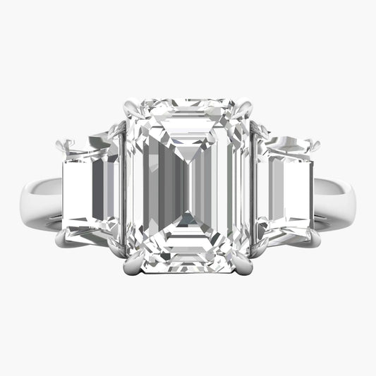 Diamond ring with emerald-cut center stone on a white background