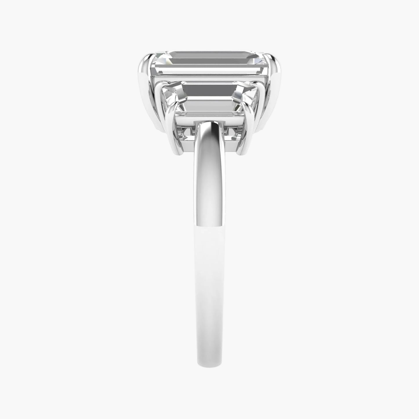 Diamond ring with emerald-cut gemstone on a white background