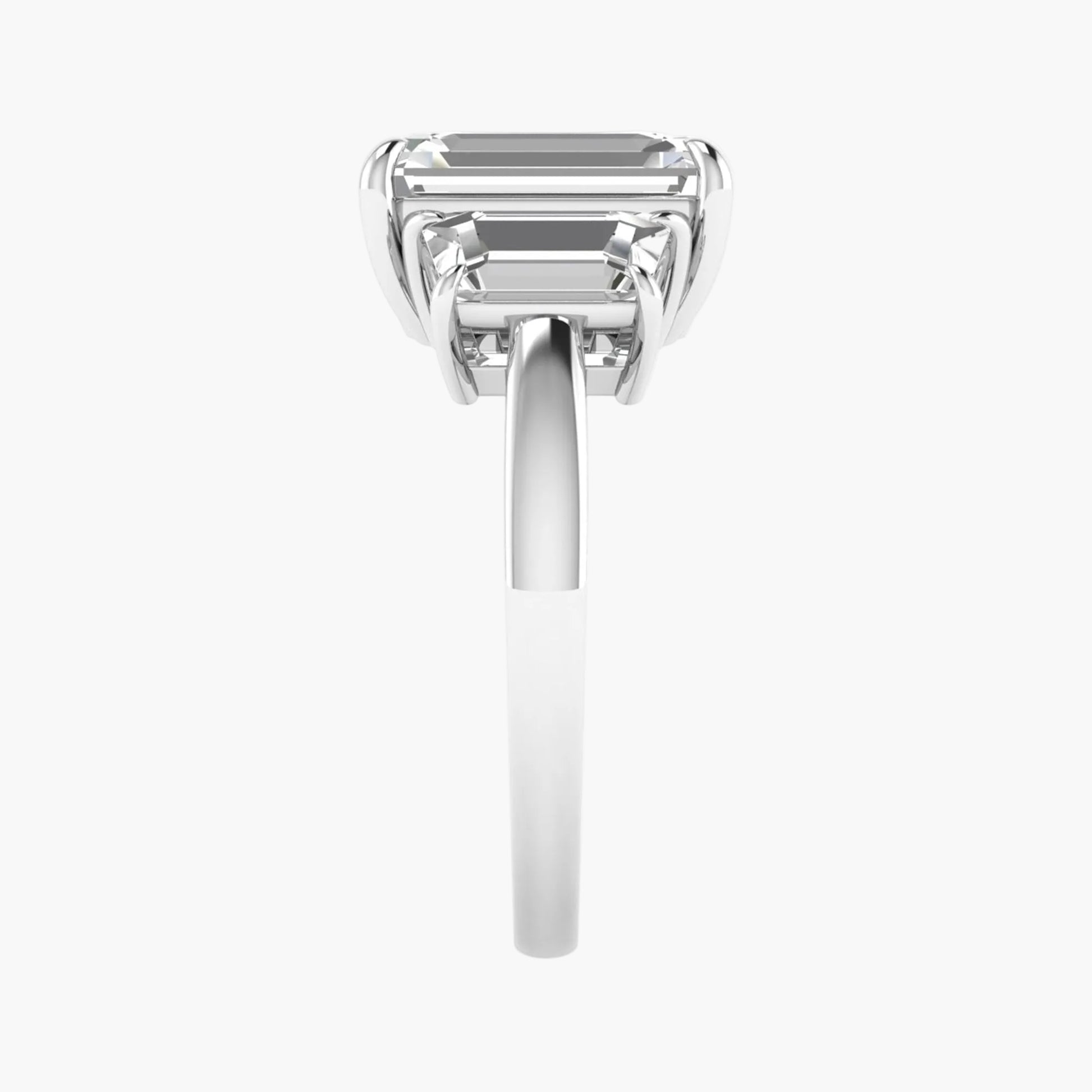 Diamond ring with emerald-cut gemstone on a white background