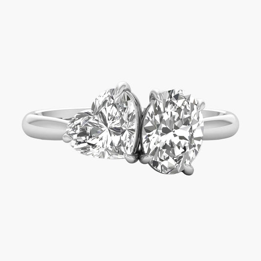 Diamond ring with two heart-shaped gemstones on a white background
