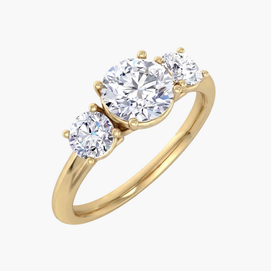 Gold ring with three clear gemstones on a white background