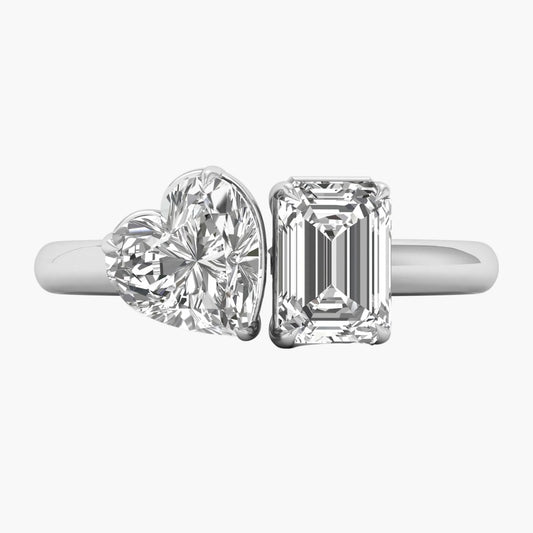 Two diamond rings, one heart-shaped and one emerald-cut, on a white background