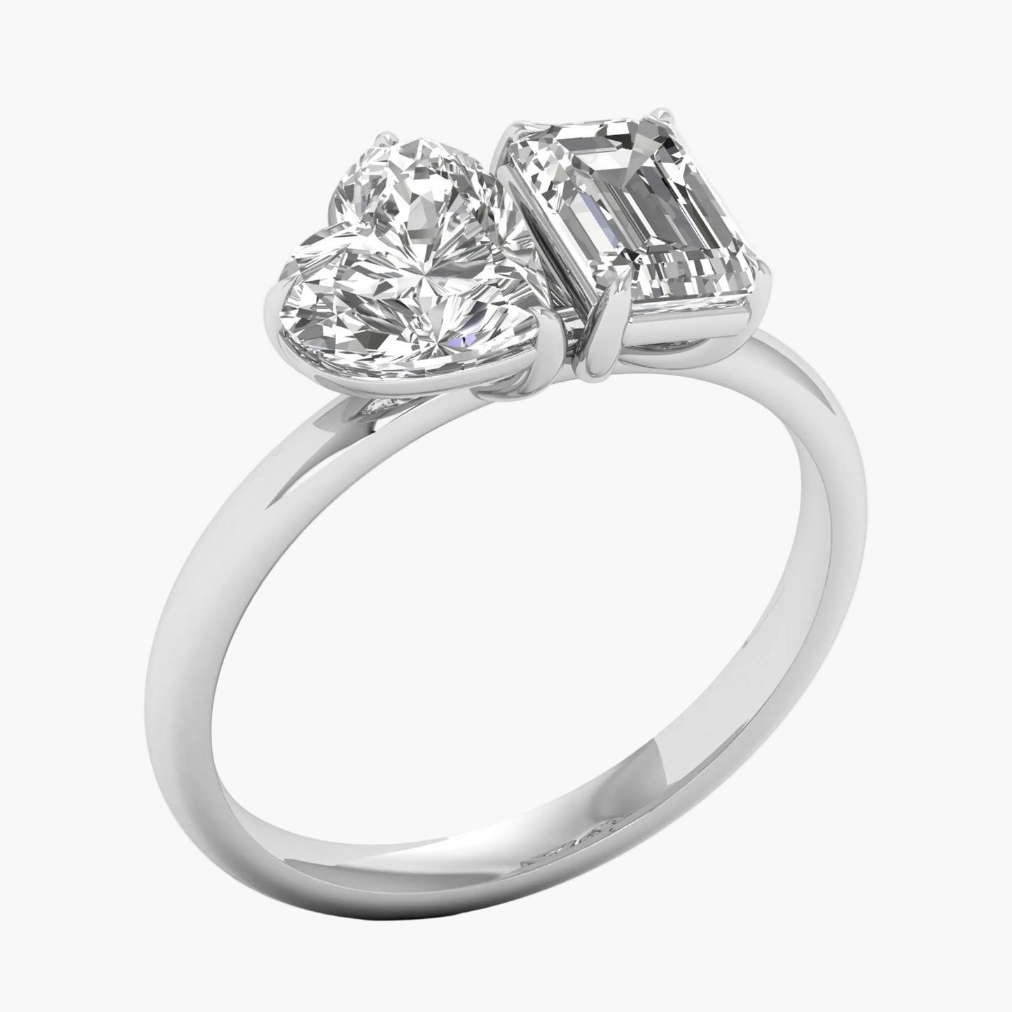 Diamond ring with heart and emerald cut stones on a white background