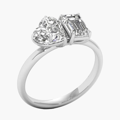Diamond ring with heart and emerald cut stones on a white background