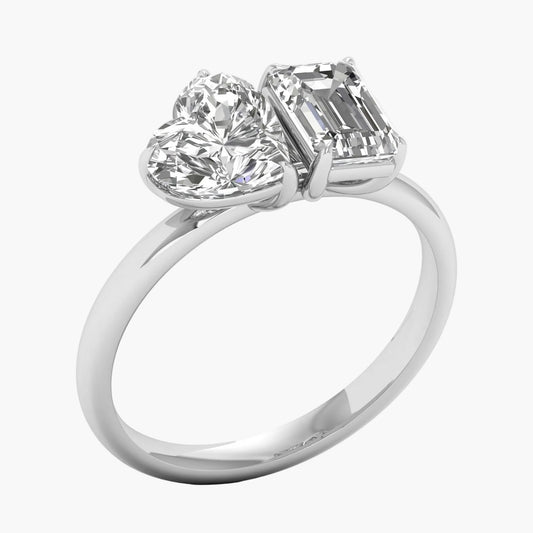 Diamond ring with heart and emerald cut stones on a white background