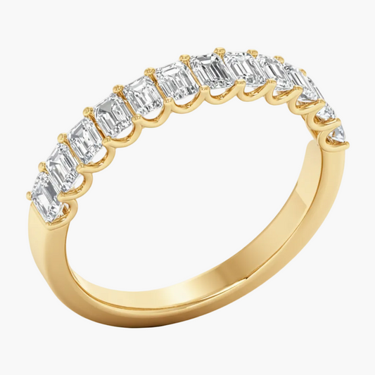 Gold ring with emerald-cut diamonds on a white background