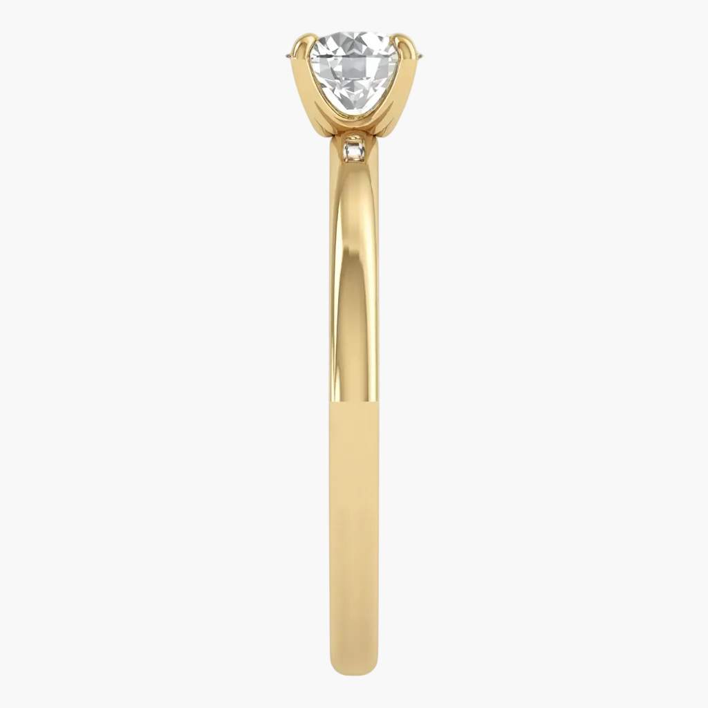 A yellow gold solitaire engagement ring featuring a heart-shaped clear gemstone in a four-prong setting, with a small accent diamond on the shank, shown against a plain white background.