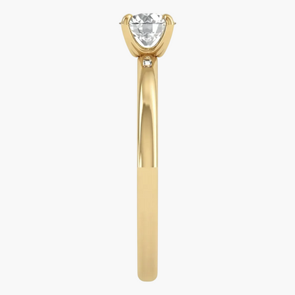 A yellow gold solitaire engagement ring featuring a heart-shaped clear gemstone in a four-prong setting, with a small accent diamond on the shank, shown against a plain white background.