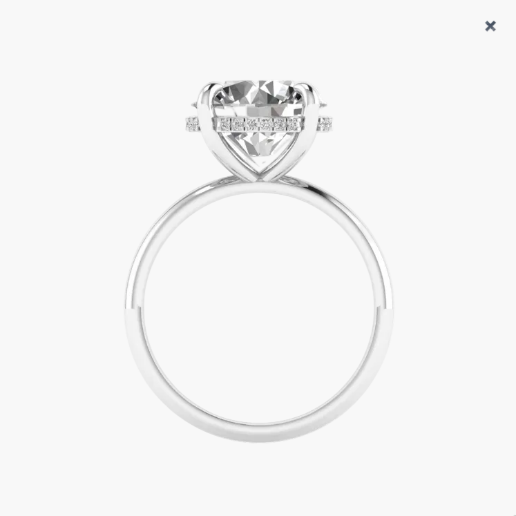 Silver ring with a large diamond and smaller diamonds on the band against a white background