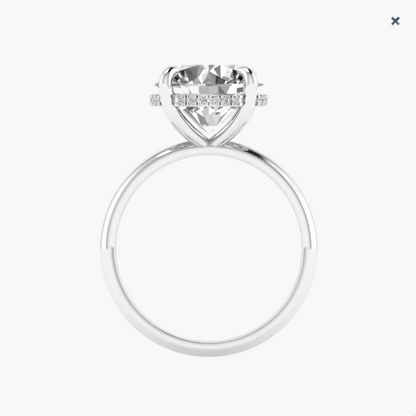 Silver ring with a large diamond and smaller diamonds on the band against a white background