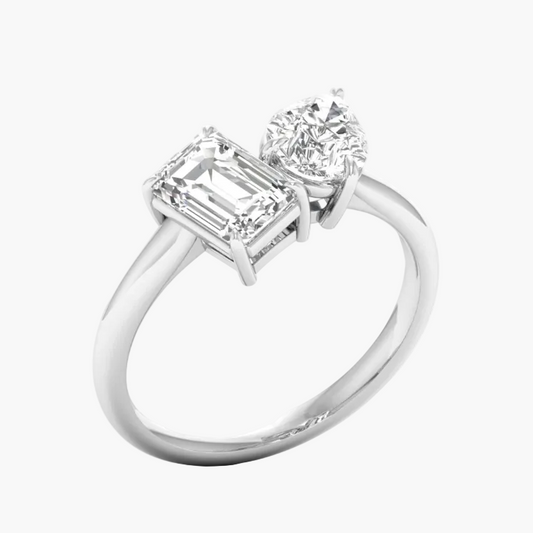 Diamond ring with emerald-cut and round diamonds on a white background