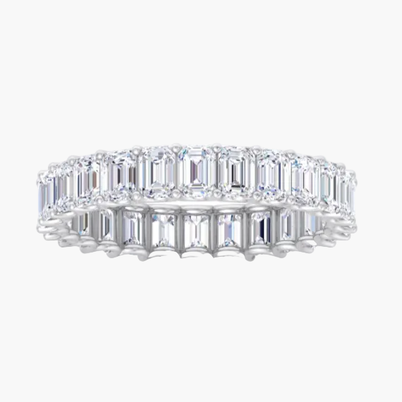 Diamond ring with emerald-cut stones on a white background