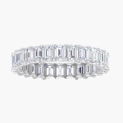 Diamond ring with emerald-cut stones on a white background