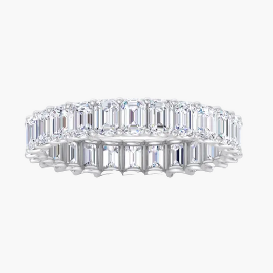 Diamond ring with emerald-cut stones on a white background