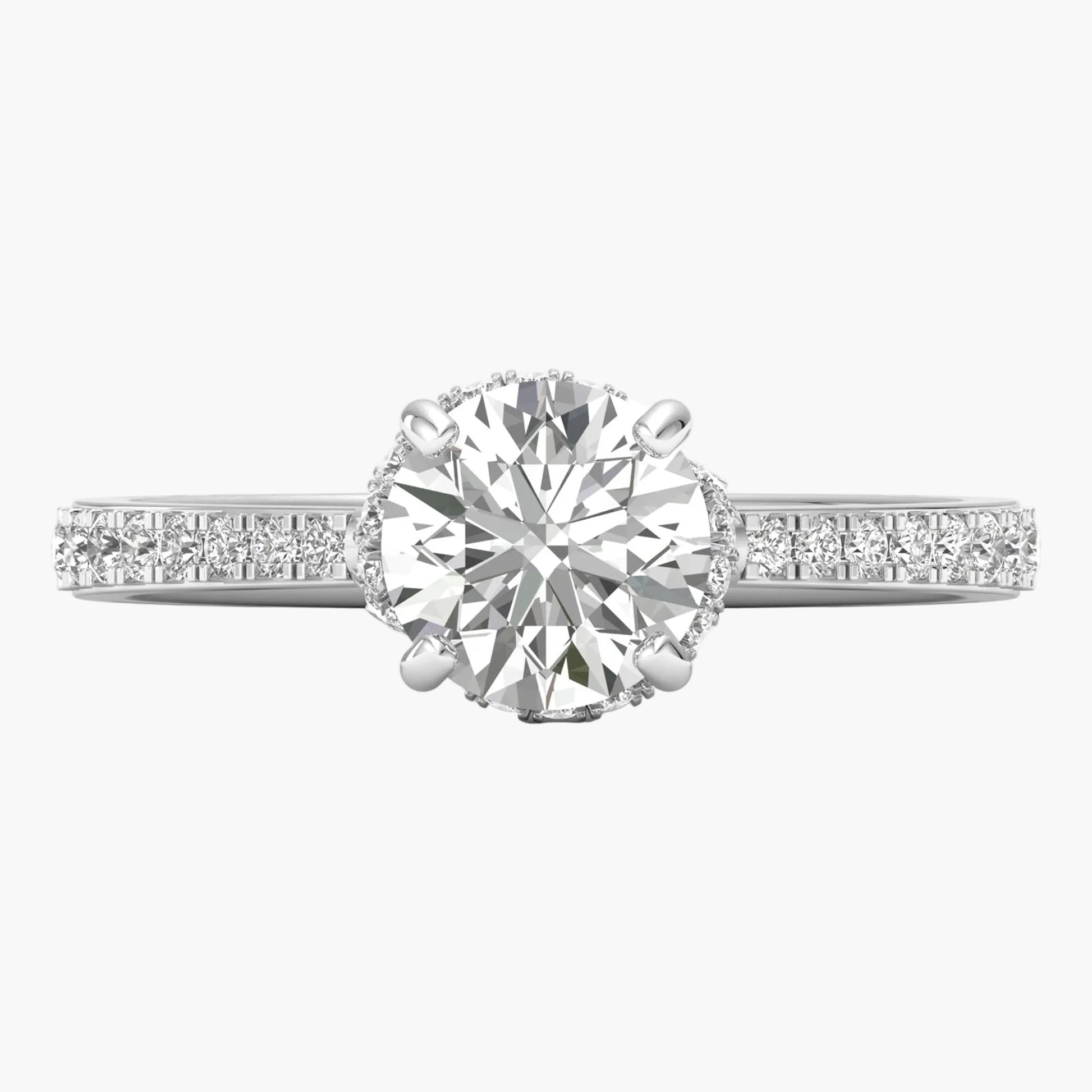 Diamond ring with a large central gemstone and smaller stones on the band against a white background