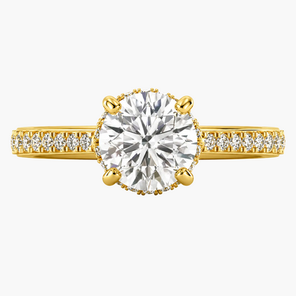 Gold ring with a large diamond and smaller diamonds on the band against a white background