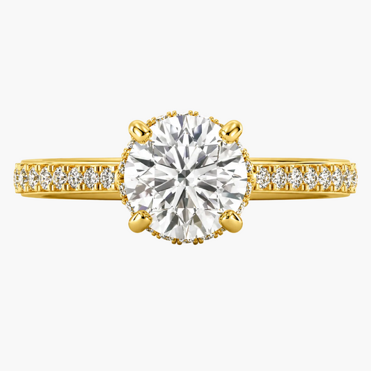Gold ring with a large diamond and smaller diamonds on the band against a white background
