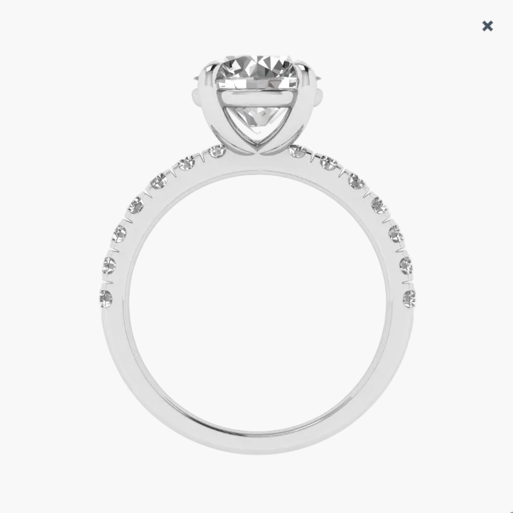 Silver ring with a large central diamond and smaller diamonds on the band against a white background