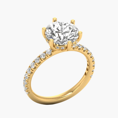 Gold ring with a large diamond and smaller diamonds on the band against a white background