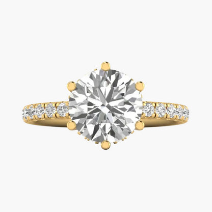 Gold ring with a large diamond and smaller diamonds on the band against a white background