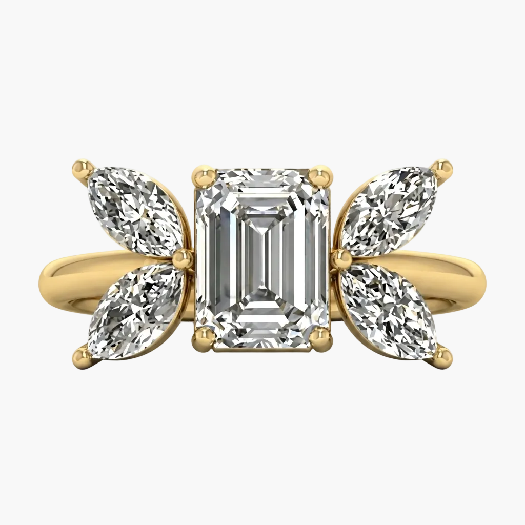 Gold ring with emerald-cut diamond and pear-shaped side stones on a white background