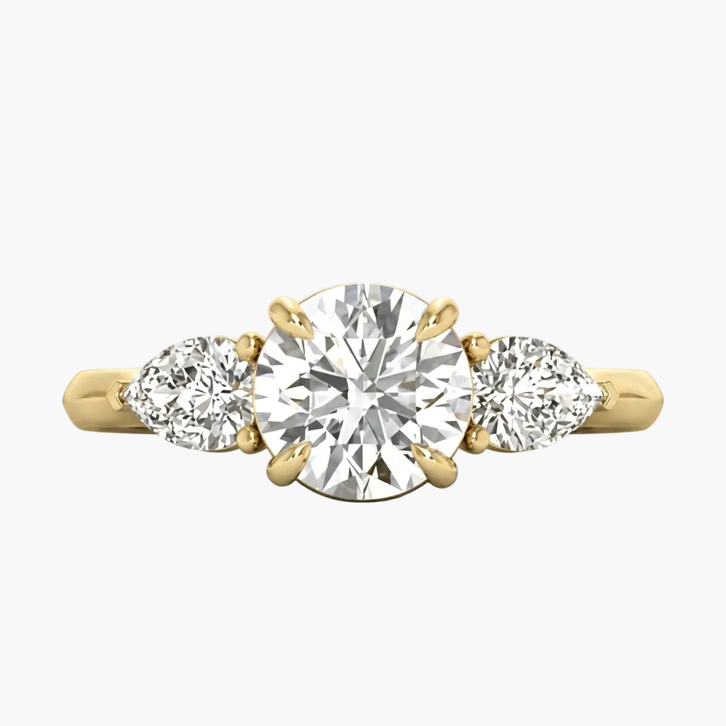 Gold ring with a central diamond flanked by two smaller diamonds on a light gray background