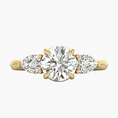 Gold ring with a central diamond flanked by two smaller diamonds on a light gray background