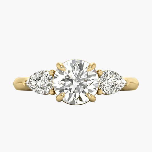 Gold ring with a central diamond flanked by two smaller diamonds on a light gray background