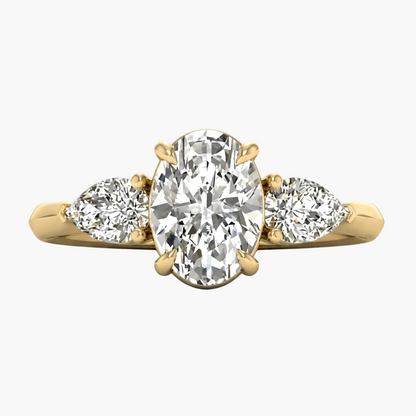 Gold ring with a central oval diamond and two pear-shaped diamonds on a white background