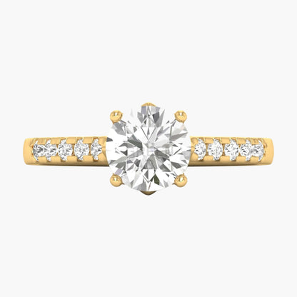Gold ring with a large diamond and smaller diamonds on the band against a white background