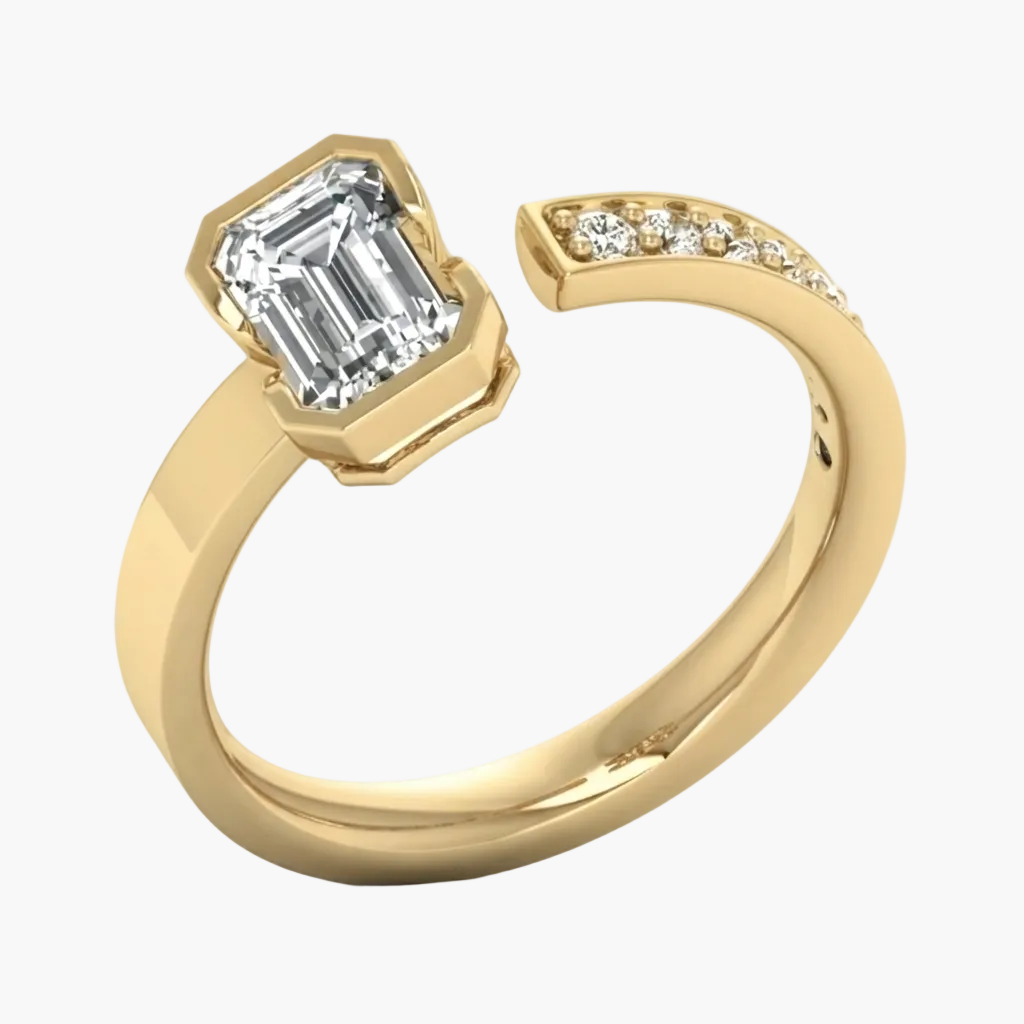 A yellow gold open band ring featuring a large emerald-cut clear center stone and a curved row of small accent stones on the shank, shown on a clean white background.