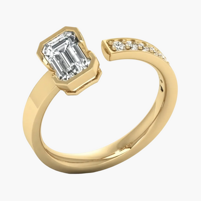 A yellow gold open band ring featuring a large emerald-cut clear center stone and a curved row of small accent stones on the shank, shown on a clean white background.