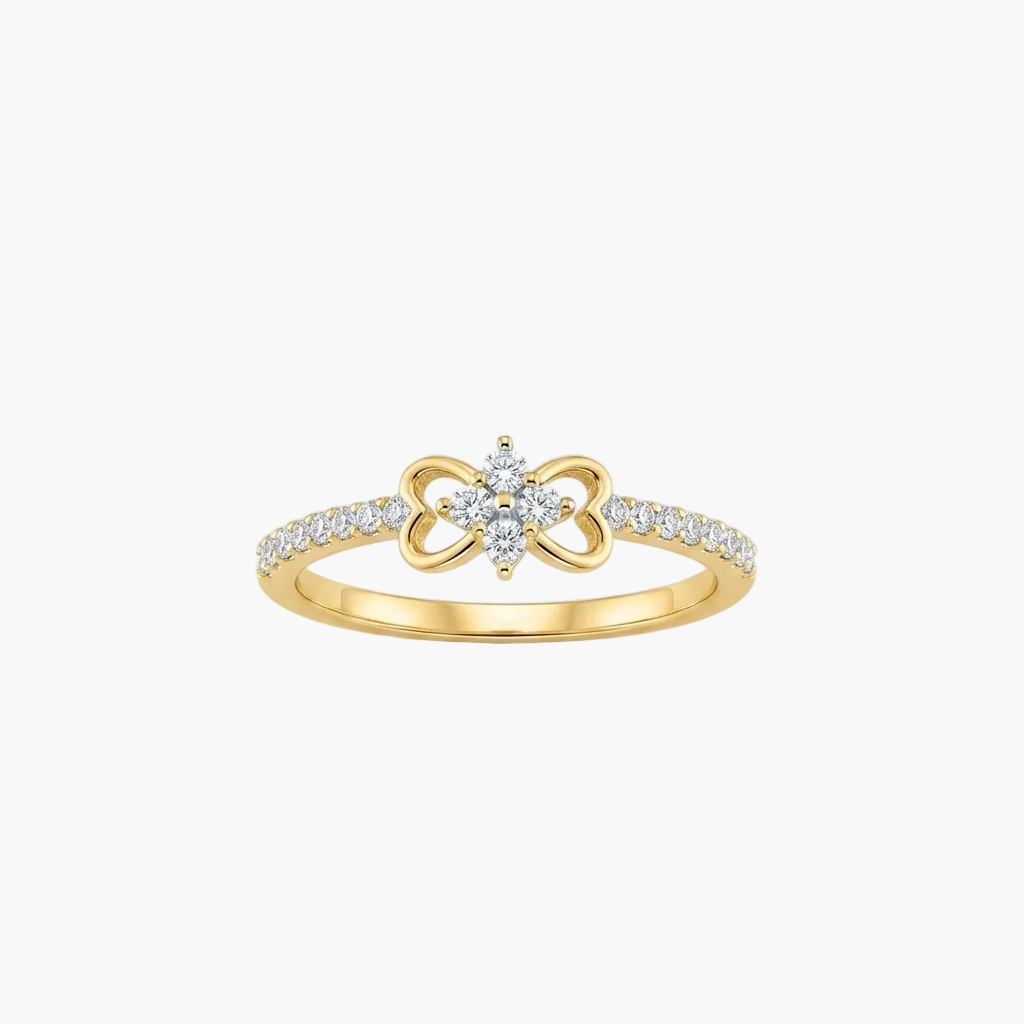 A yellow gold ring featuring a bow-shaped centerpiece with a small cluster of clear stones in the center and a pavé band with small round stones, shown on a light gray background.
